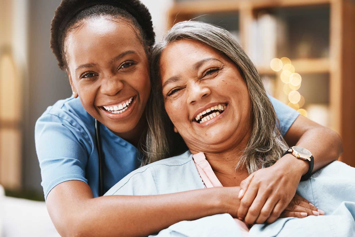 A care professional and an adult sharing a happy moment at home