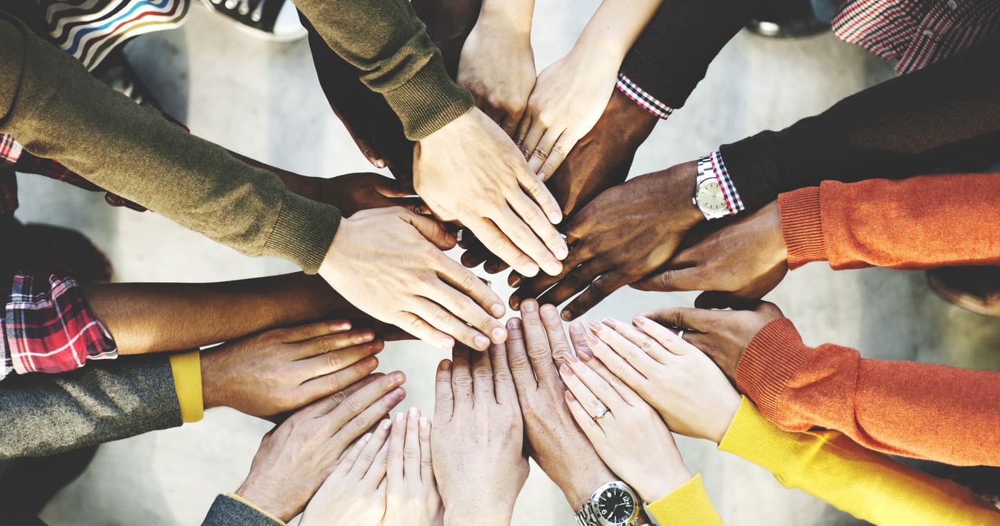 Many hands joined together in a circle