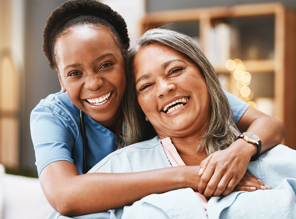 A smiling adult sharing a warm moment with a care professional